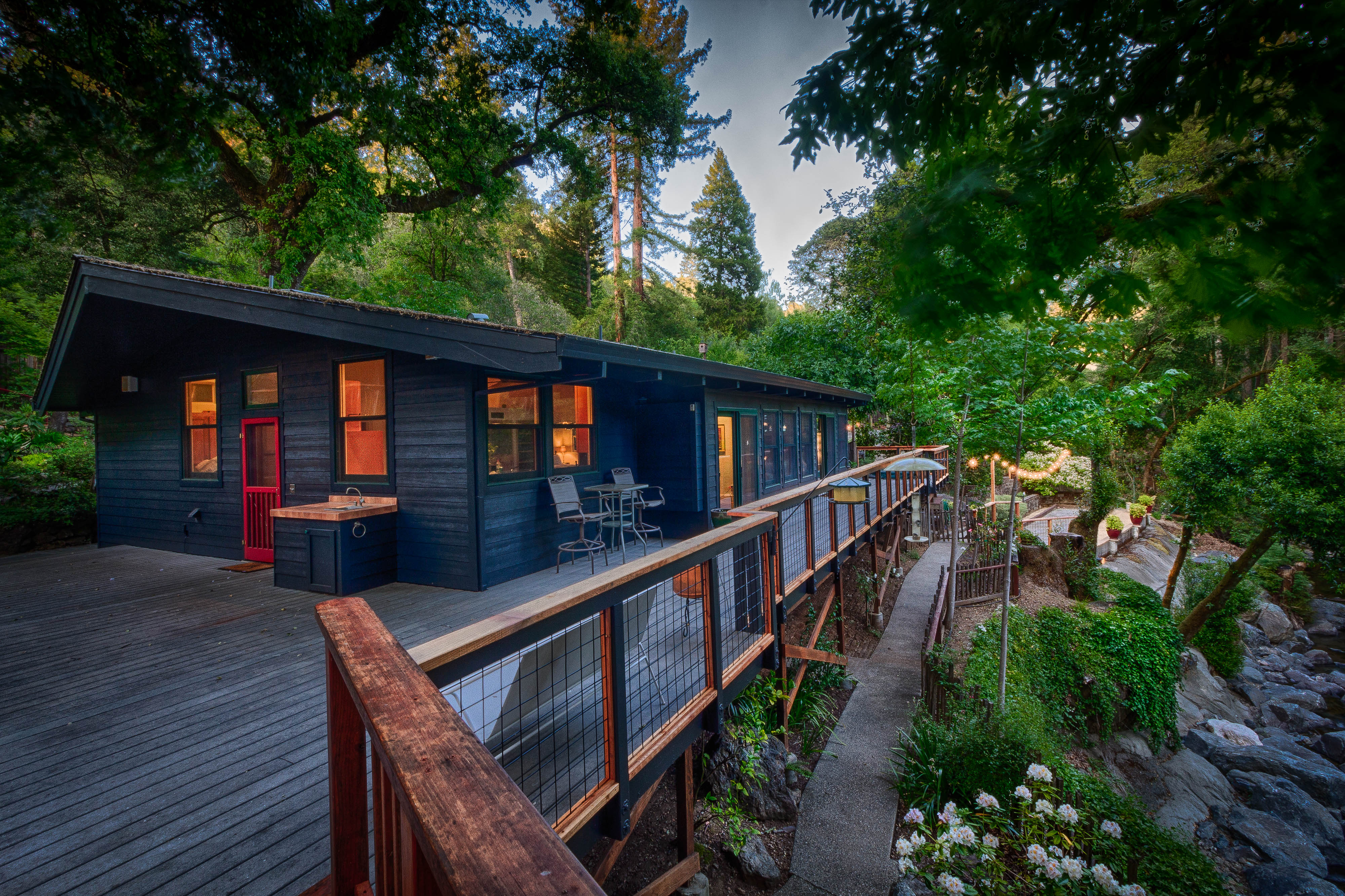 A timber walkway following the dark cabin through the grove