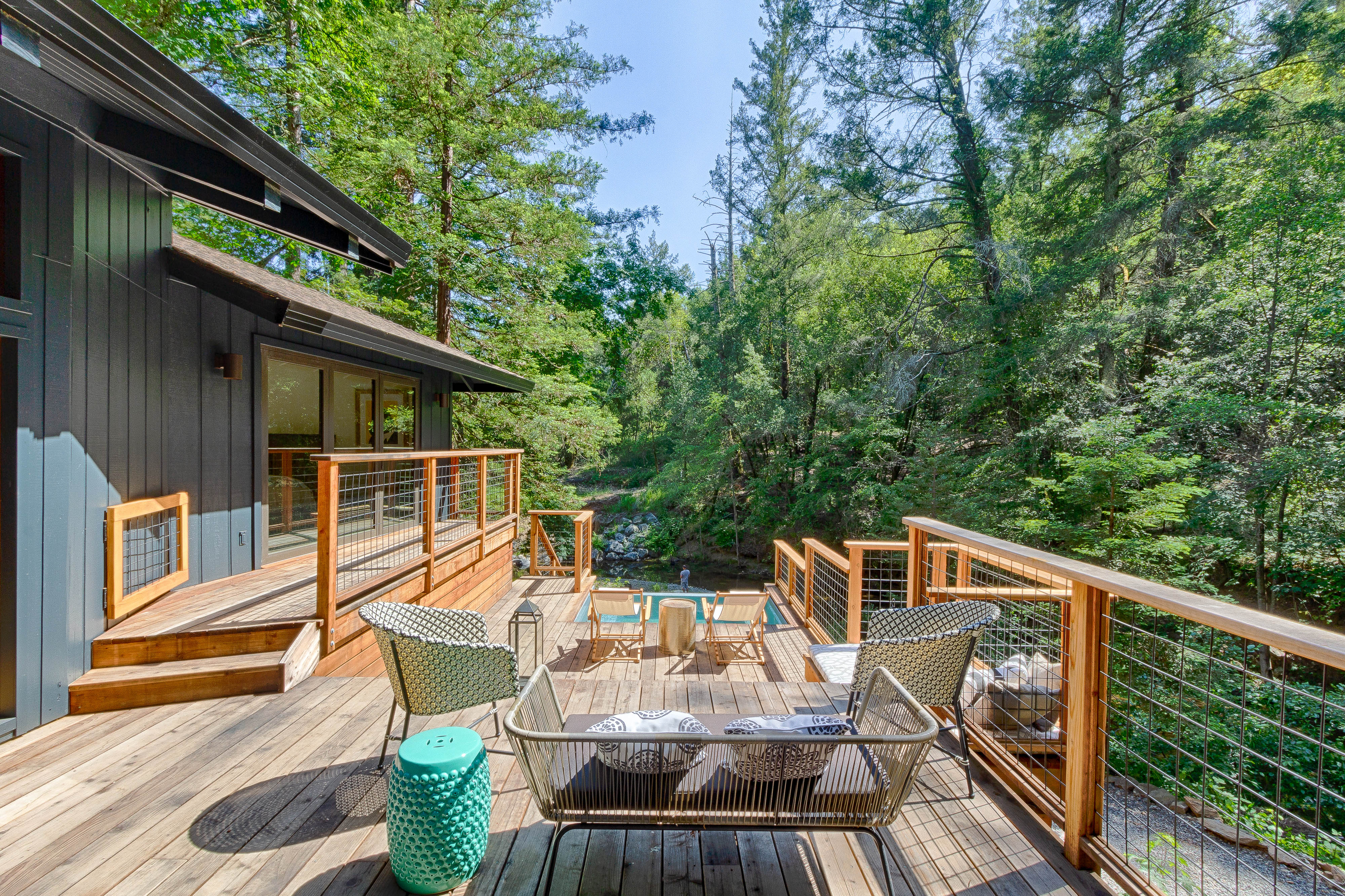 An outdoor table and lounge chairs on the deck above the grove